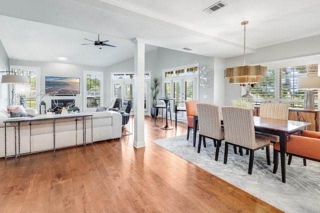 dining room with hardwood / wood-style floors, lofted ceiling, ceiling fan, and decorative columns