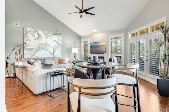 living room featuring hardwood / wood-style floors, high vaulted ceiling, and ceiling fan