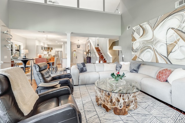 living room with light wood-type flooring and a high ceiling