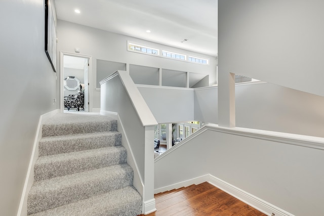 stairs featuring hardwood / wood-style floors