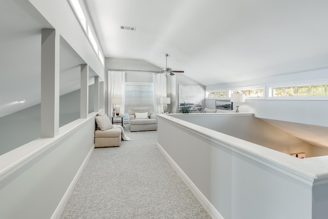 hall with light colored carpet and lofted ceiling