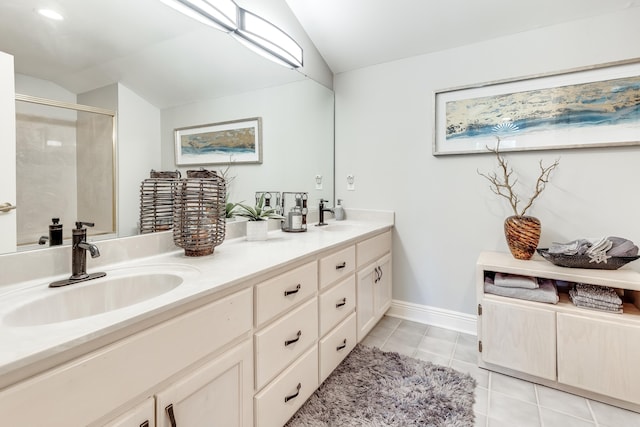 bathroom with a shower with shower door, vaulted ceiling, tile patterned flooring, and vanity