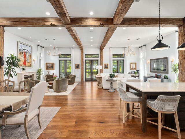 dining room featuring light wood-type flooring, a wealth of natural light, an inviting chandelier, and french doors