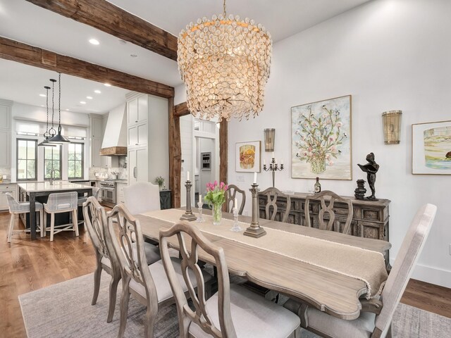 dining space featuring hardwood / wood-style floors, sink, a notable chandelier, and beamed ceiling