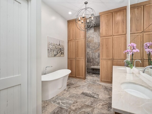 bathroom with tile patterned flooring, a notable chandelier, a bath, and vanity