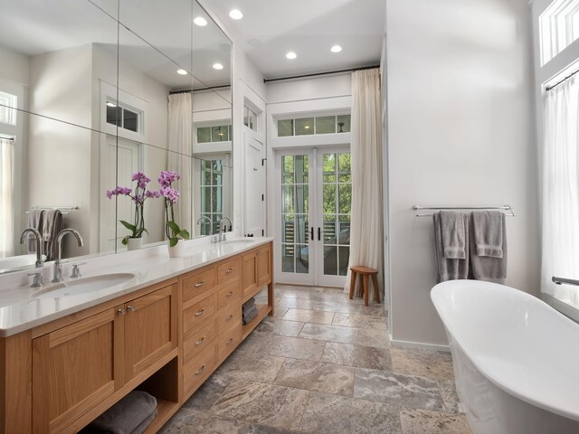 bathroom featuring a bath, tile patterned floors, french doors, and vanity