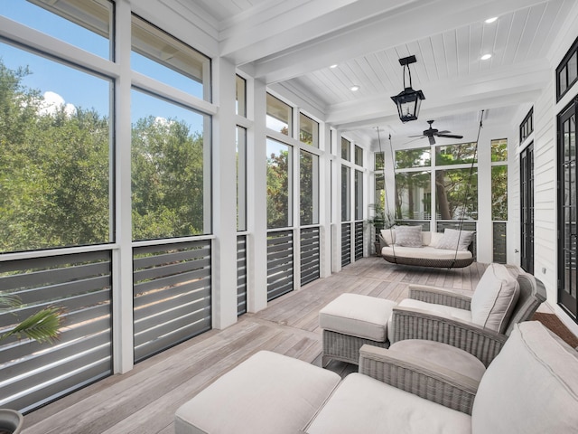 sunroom featuring beam ceiling and ceiling fan