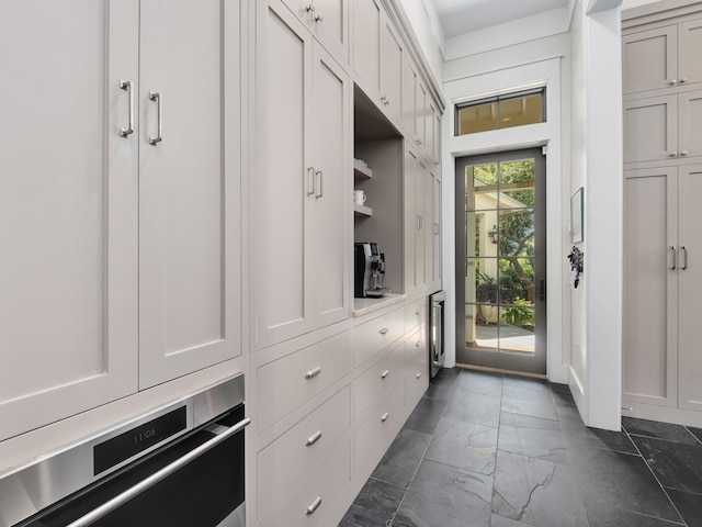 mudroom featuring dark tile patterned floors and beverage cooler