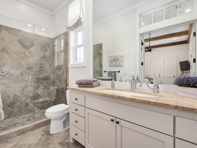 bathroom with beam ceiling, toilet, vanity, a shower with shower door, and ceiling fan