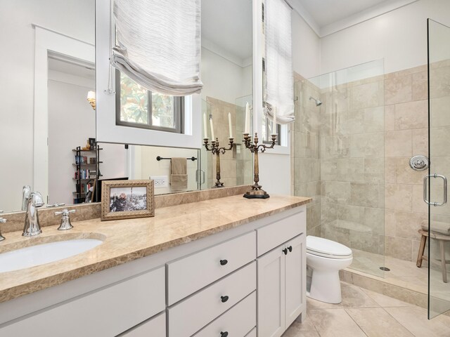 bathroom with toilet, an enclosed shower, vanity, ornamental molding, and tile patterned floors