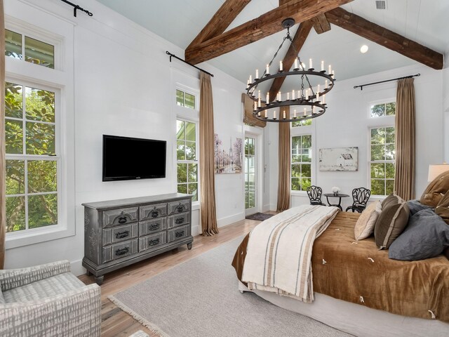 bedroom featuring hardwood / wood-style floors, a notable chandelier, beamed ceiling, and multiple windows