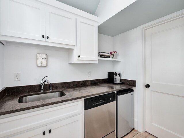 kitchen with sink, dishwasher, white cabinets, and dark stone countertops