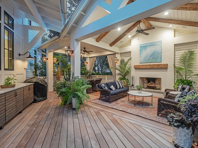 wooden deck featuring ceiling fan, area for grilling, and an outdoor living space with a fireplace