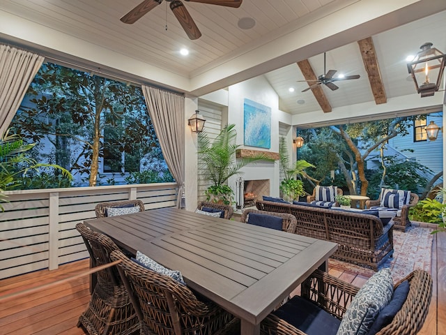 wooden deck with ceiling fan and an outdoor living space with a fireplace