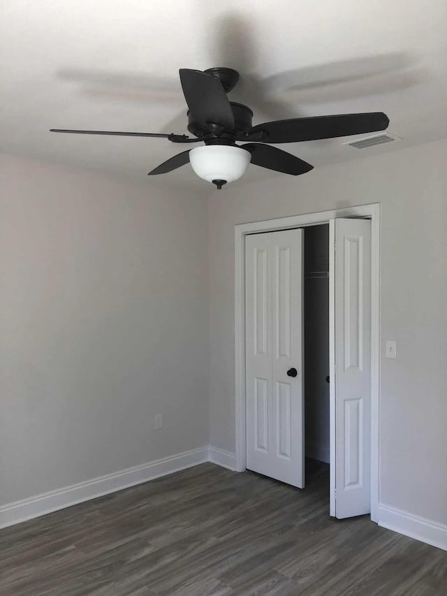 unfurnished bedroom with a closet, ceiling fan, and dark hardwood / wood-style floors