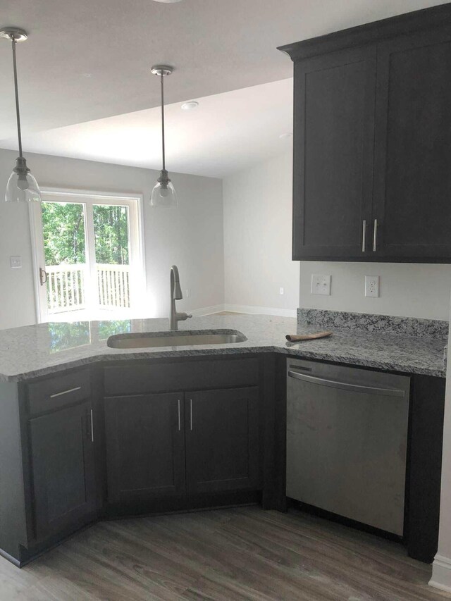 kitchen featuring sink, stainless steel dishwasher, hardwood / wood-style flooring, and light stone countertops