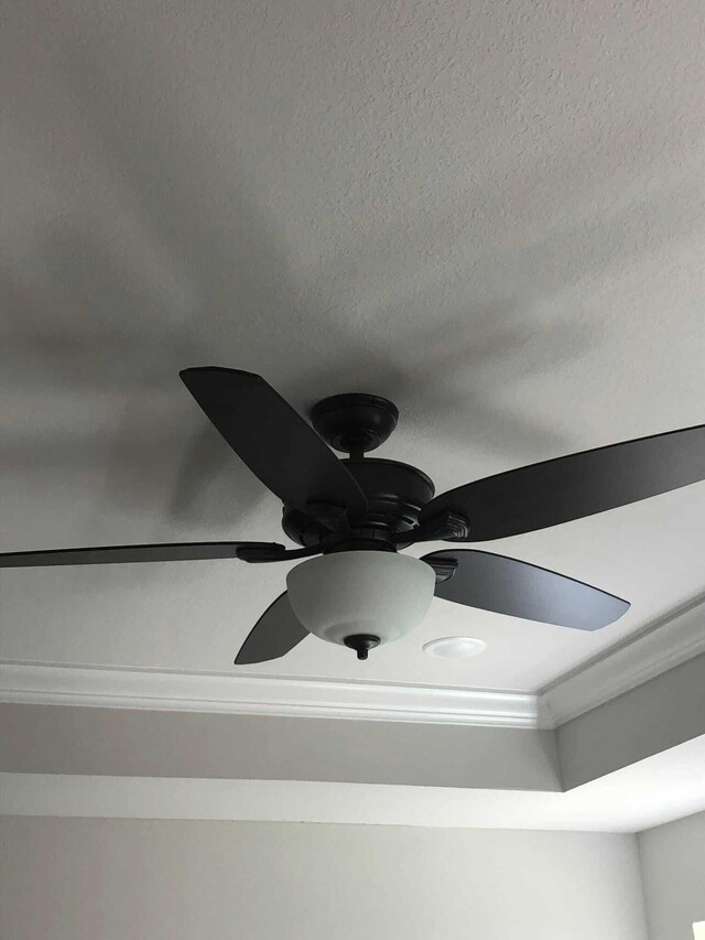 room details with ceiling fan and a textured ceiling