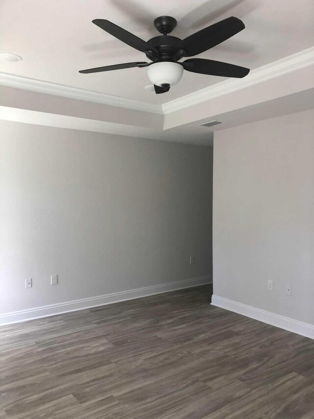 spare room featuring ceiling fan, a raised ceiling, hardwood / wood-style floors, and ornamental molding