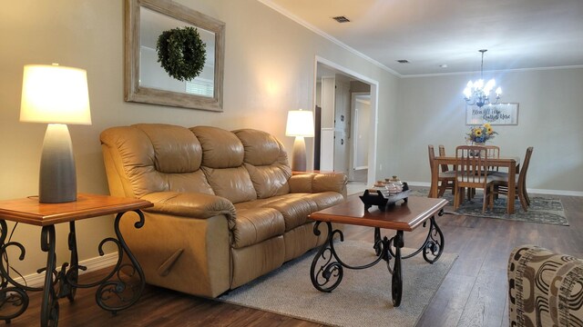 living room featuring ornamental molding, dark wood-type flooring, and a notable chandelier