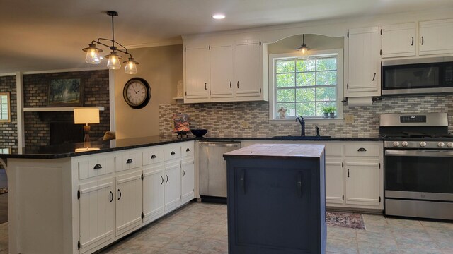 kitchen with appliances with stainless steel finishes, sink, and white cabinets