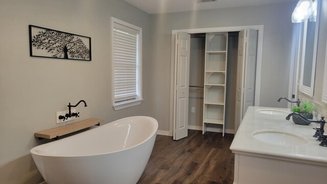 bathroom featuring vanity, hardwood / wood-style floors, and a tub