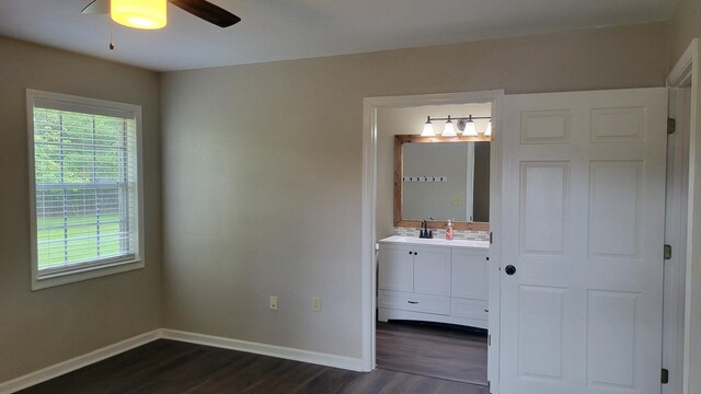 unfurnished bedroom with ceiling fan, connected bathroom, dark hardwood / wood-style flooring, and sink