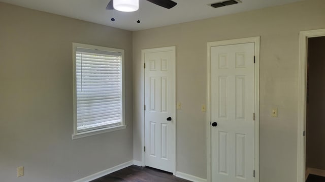 unfurnished bedroom with dark wood-type flooring and ceiling fan