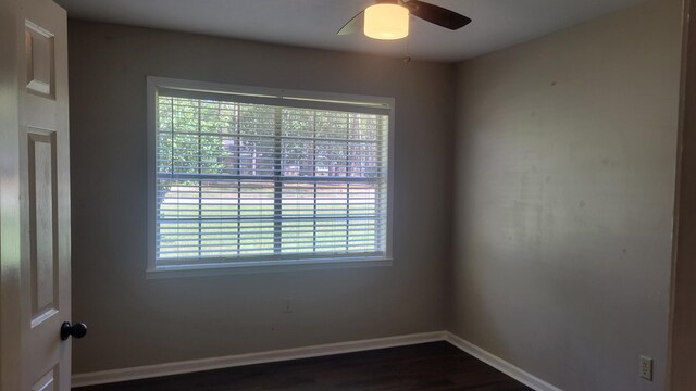 spare room with dark wood-type flooring, ceiling fan, and plenty of natural light