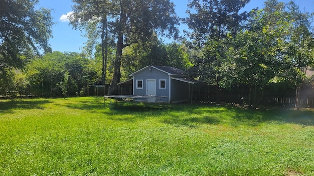 view of yard featuring an outdoor structure and a trampoline