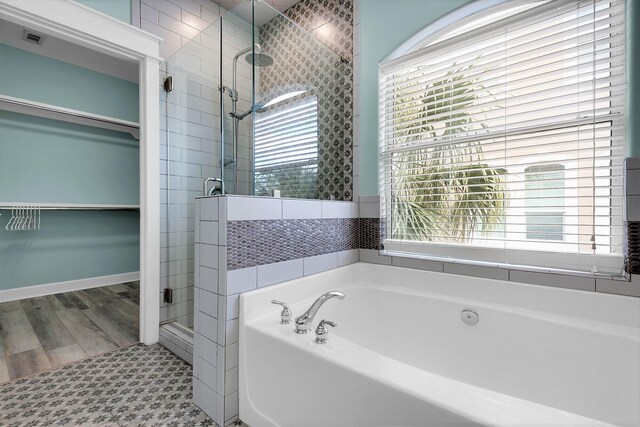 bathroom with hardwood / wood-style flooring, separate shower and tub, and plenty of natural light