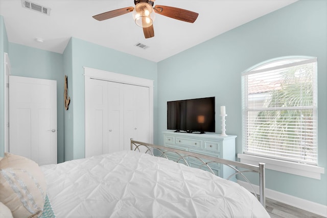 bedroom featuring ceiling fan, a closet, and light hardwood / wood-style flooring