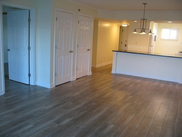 kitchen with hanging light fixtures, dark wood-style floors, and baseboards