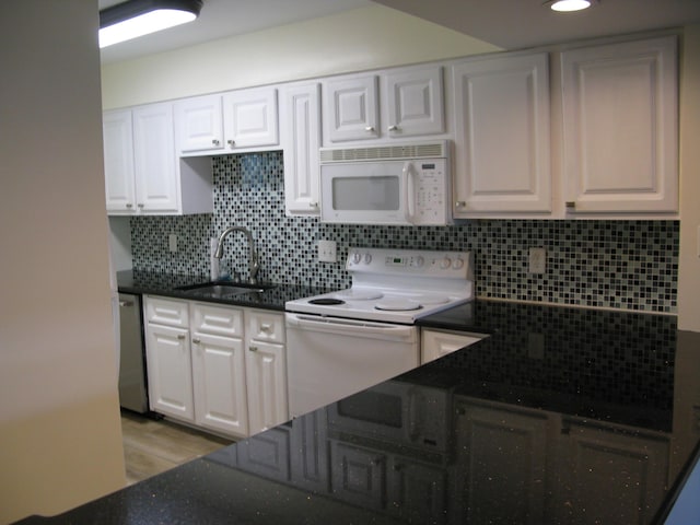 kitchen featuring tasteful backsplash, white appliances, a sink, and white cabinets