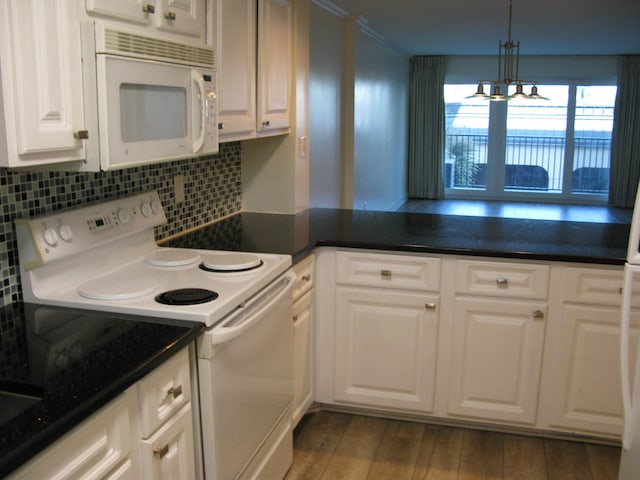 kitchen featuring dark countertops, white appliances, and white cabinets