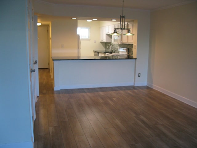 kitchen with dark wood-style flooring, baseboards, white cabinets, dark countertops, and pendant lighting