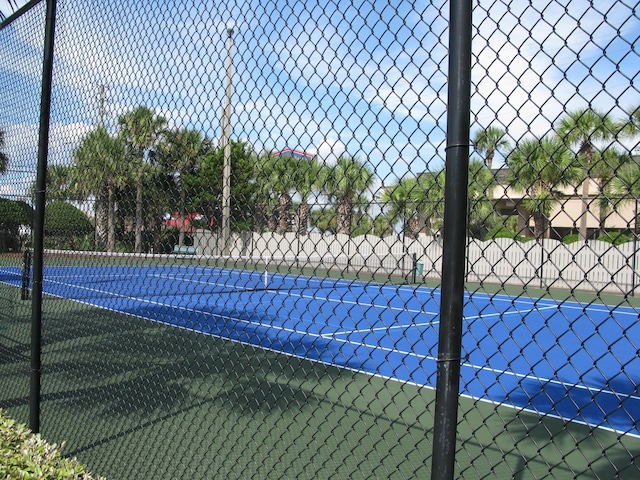 view of tennis court featuring fence