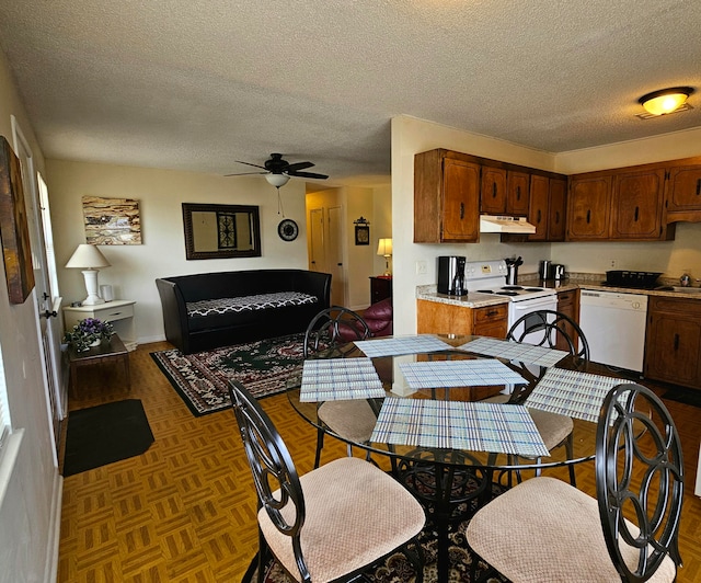 dining area featuring ceiling fan, parquet floors, sink, and a textured ceiling