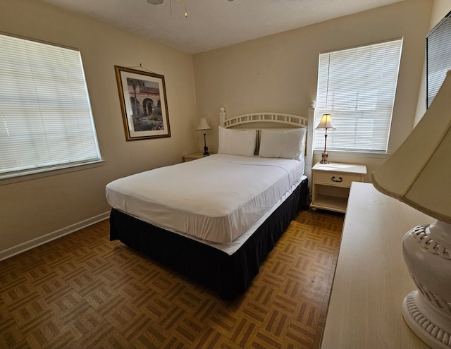 bedroom with a textured ceiling and dark parquet flooring