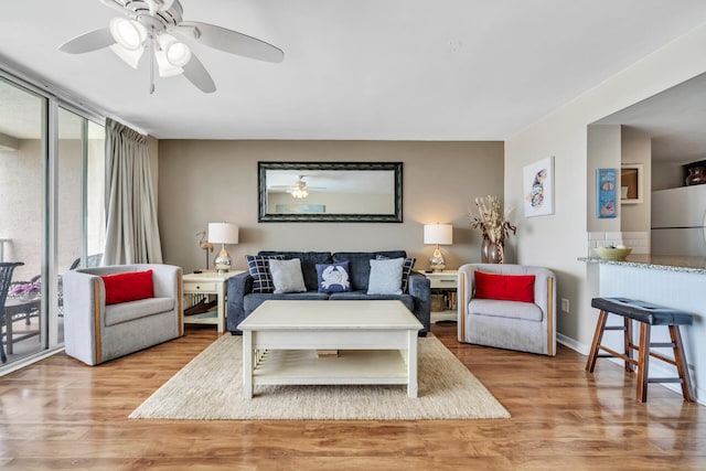 living room with ceiling fan and light wood-type flooring