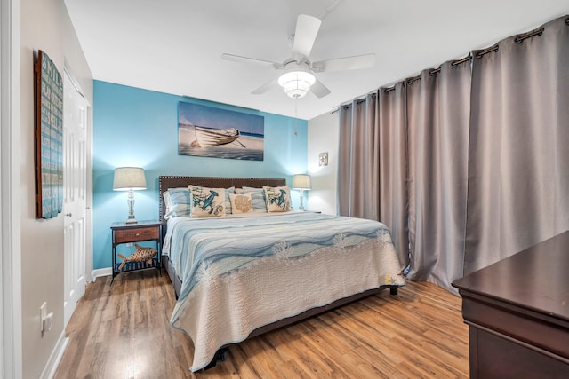 bedroom with ceiling fan, light wood-type flooring, and a closet