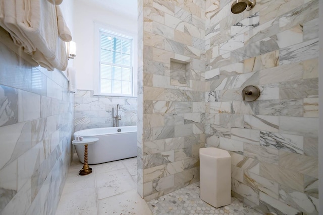 bathroom featuring a freestanding bath, a tile shower, and tile walls