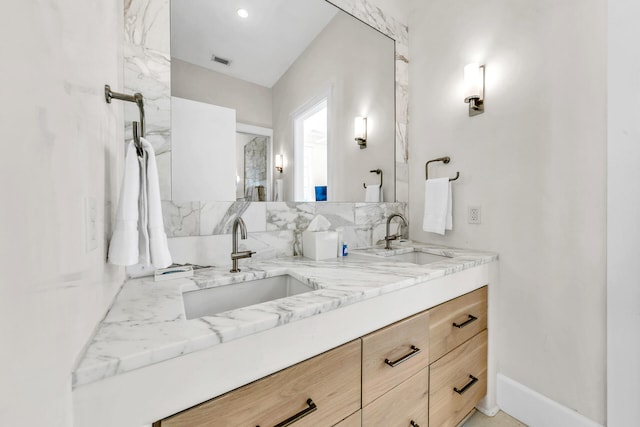 full bathroom featuring double vanity, visible vents, decorative backsplash, and a sink