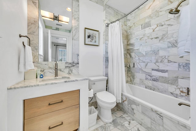 bathroom with marble finish floor, tiled shower / bath, toilet, and vanity