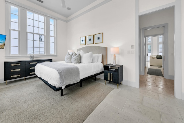 bedroom featuring baseboards and stone tile flooring