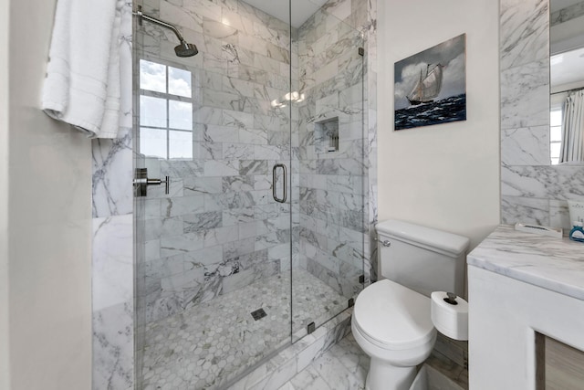 full bath with marble finish floor, a shower stall, toilet, and vanity