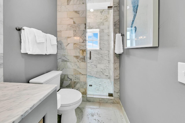 full bathroom featuring a stall shower, baseboards, vanity, and toilet