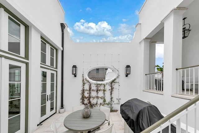 balcony with french doors, a grill, and a patio