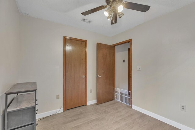 unfurnished bedroom featuring light wood-type flooring and ceiling fan