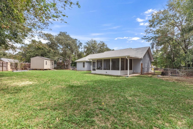 rear view of house featuring a lawn and a storage unit