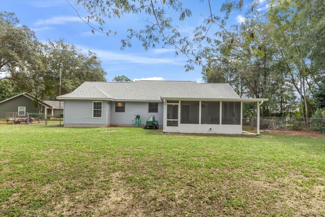 back of property featuring a lawn and a sunroom